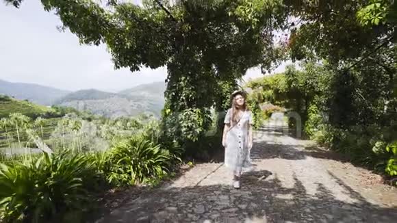 女的走在小巷里群山之间有藤蔓植物视频的预览图