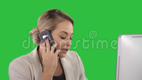年轻的办公室女性在绿色屏幕上与手机上的人交谈Chroma键视频的预览图