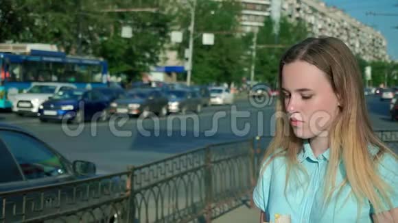 在城里大街上吃薯条的年轻女孩视频的预览图