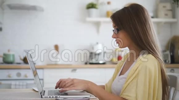 年轻女性棕色长发在笔记本电脑键盘上快速打字视频的预览图