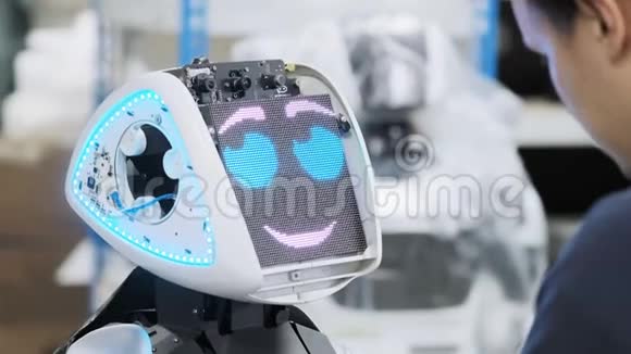 生产机器人的工厂工程师调整键盘为新机器人创建软件视频的预览图