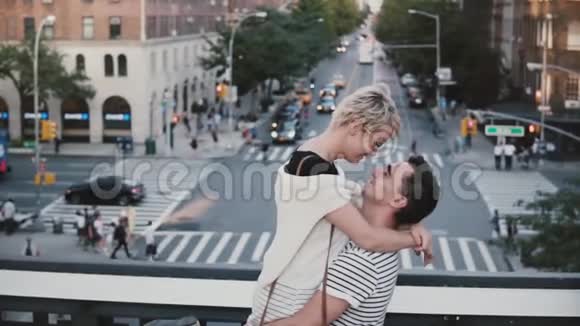慢动作快乐的西班牙男人抱着欧洲女孩年轻浪漫的情侣在纽约的一座桥上旋转视频的预览图