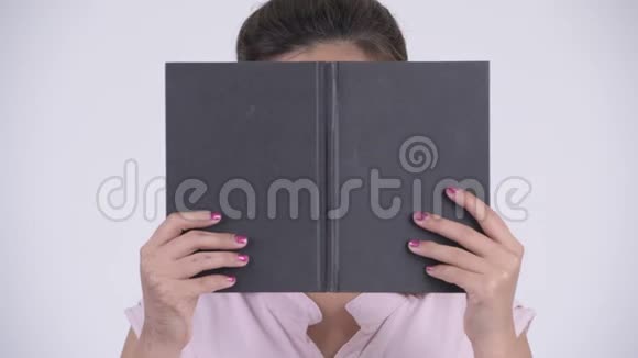 年轻漂亮的亚洲女商人的脸用书本遮住脸视频的预览图