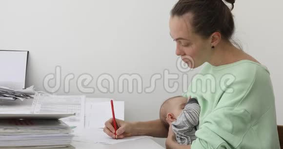 女人喂养婴儿和使用工作视频的预览图
