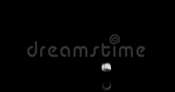 一杯牛奶在黑色背景上弹跳和飞溅慢动作视频的预览图