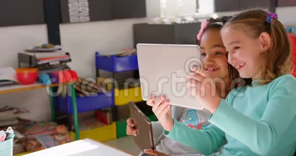 4k教室里在数码平板电脑上学习的混血女学生的侧视图视频的预览图