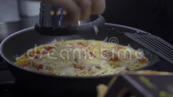 女人用煎锅把奶酪涂在炒鸡蛋上视频的预览图