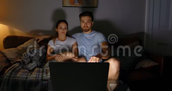 一对夫妇在家里用笔记本电脑看电影视频的预览图