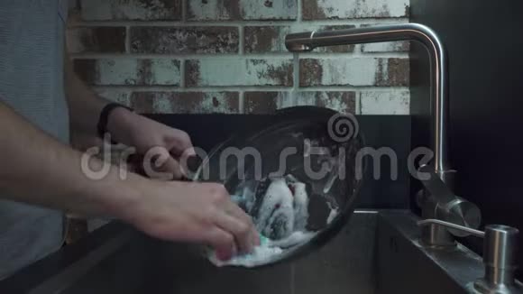 男人在厨房里用海绵洗锅视频的预览图