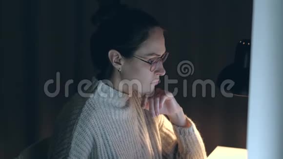 晚上坐在电脑前的黑发女人视频的预览图