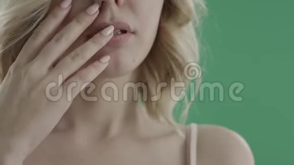 性感的金发女郎用绿色屏幕抚摸她的脸脖子和肩膀视频的预览图