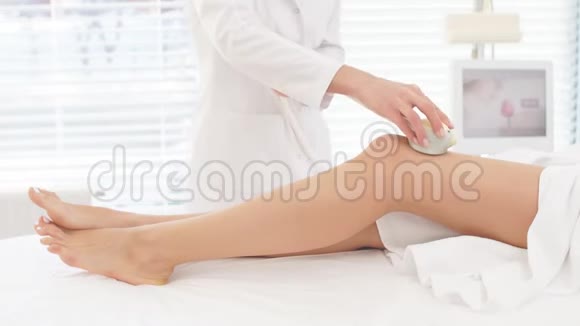 女性美容师在美容院对女性长腿做Rf提升手术视频的预览图
