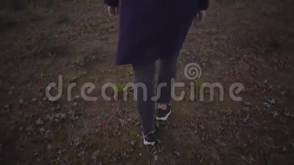 穿着运动鞋的女人慢慢地穿过草地视频的预览图
