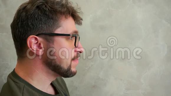 饥饿的长胡子男人戴着眼镜吃着美味的汉堡包缓行视频的预览图