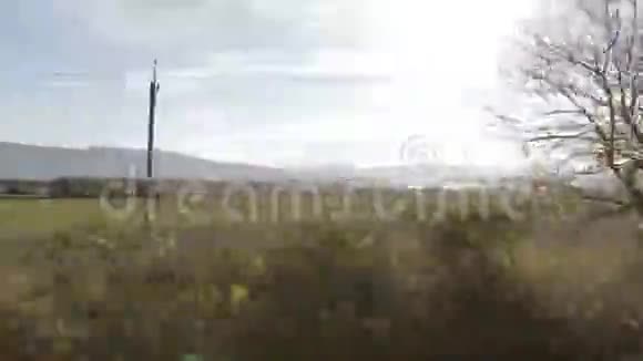 汽车侧窗观赏乡村景观日落时观山观湖沿电源线在农村公路上行驶视频的预览图