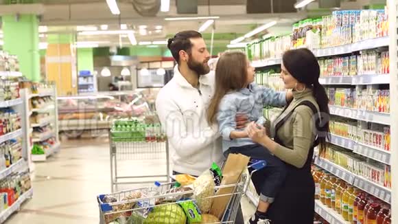 漂亮的父母和他们的女儿正在超市里选择糖果慢节奏视频的预览图