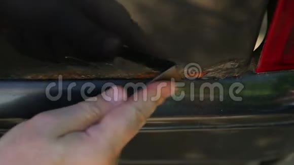 一个人用刮刀清理车身上的铁锈视频的预览图