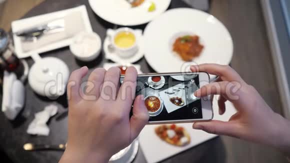 女人在咖啡馆里通过电话拍下食物视频的预览图
