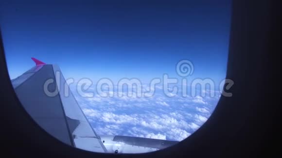 蓝天白云和机翼从窗口飞行的客机蓝天白云上的飞机翼视频的预览图