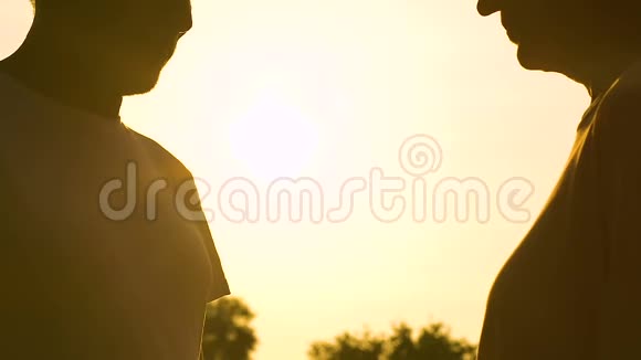 男人给女人送花他们在夕阳的背景下接吻浪漫的时刻视频的预览图