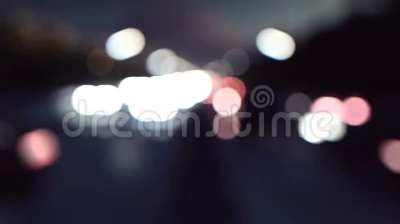 离焦汽车灯和背景运动夜间开灯的汽车穿过城市宽松现实视频的预览图
