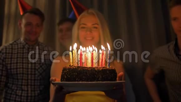 美丽的女人和朋友一起庆祝生日一起在蛋糕上点蜡烛视频的预览图