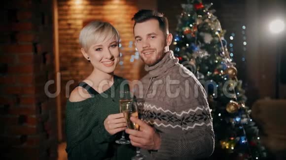 圣诞节时一对年轻夫妇正高兴地互相亲吻手里拿着一杯香槟视频的预览图