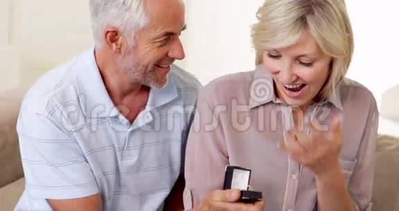 成熟的男人在沙发上向伴侣求婚视频的预览图