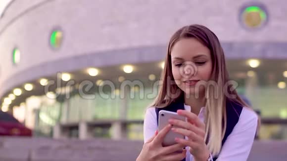 年轻迷人的女孩在晚上在智能手机上自拍在市中心视频的预览图