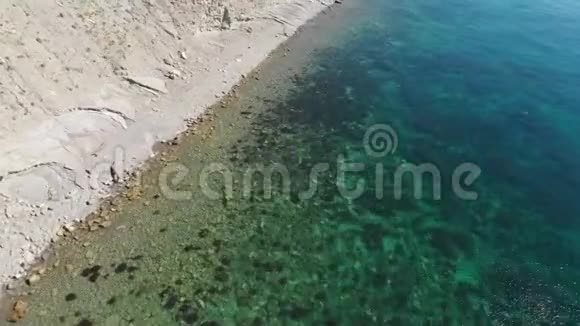 海洋海岸线与石滩和清澈的蓝色水从无人机上景空中景观视频的预览图