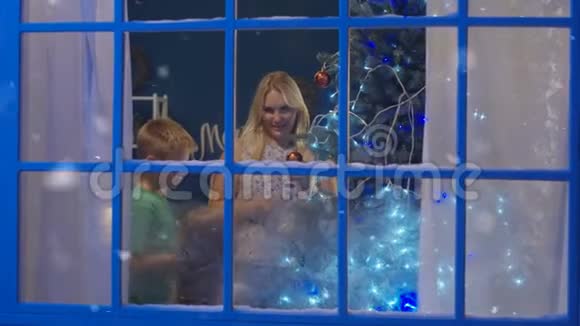 带着孩子在家装饰圣诞树的女人视频的预览图