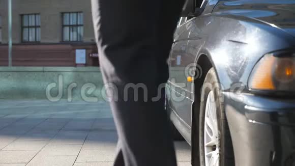 男子为女乘客揭开汽车之门商人来到汽车旁为美丽的人开门视频的预览图