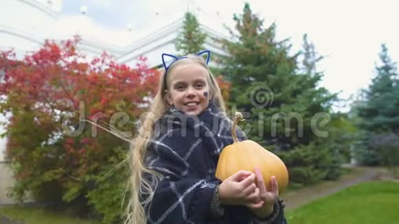 开朗的女孩伸出大拇指举着杰克南瓜过万圣节秋天的假期视频的预览图