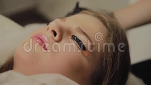 一个非常漂亮的女孩在美容院做一个层叠睫毛躺着等待睫毛上的干燥油漆视频的预览图