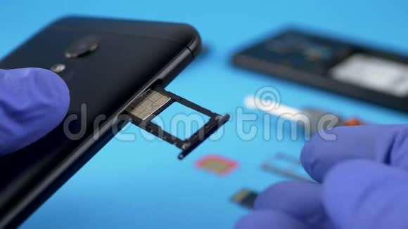 蓝手套安装黑色智能手机SIM卡视频的预览图