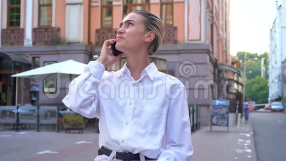年轻的现代女性站在街上打电话预约沟通观念城市观念视频的预览图
