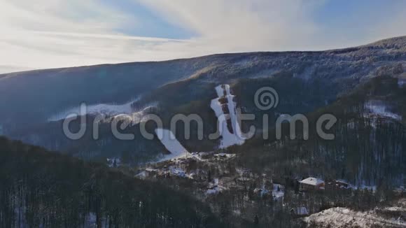 空中无人机在背景冬季的山村景色雪天美丽的山视频的预览图