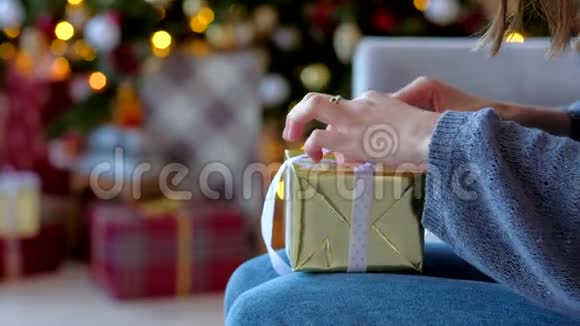 关闭女人的手准备一个新年惊喜绑在一个金盒子与礼物鞠躬2019年圣诞节视频的预览图