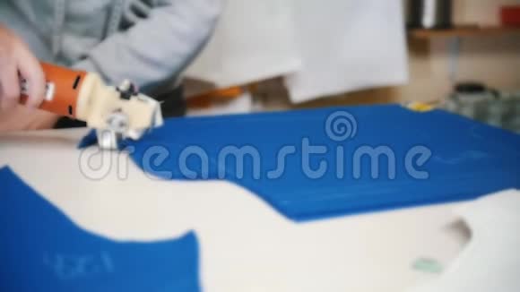 工人在工厂切割蓝色布使用特殊的仪器跟随标记很模糊慢动作视频的预览图