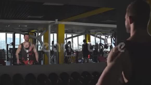 肌肉发达的年轻人在健身房用哑铃锻炼二头肌视频的预览图