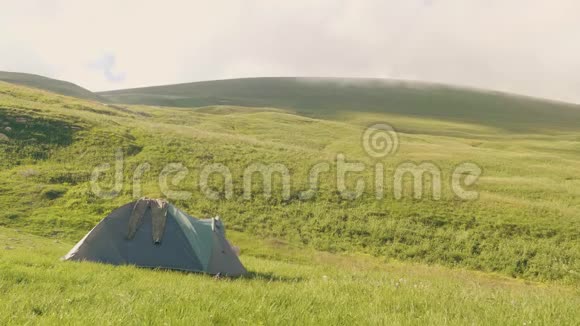 游客从绿色草地和山地露营帐篷里出来视频的预览图