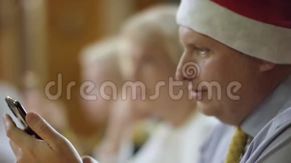 老人在家庭圣诞晚餐时在智能手机上发短信关门视频的预览图