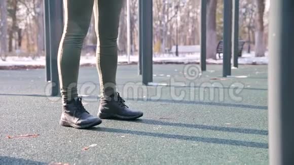 在皮带下面查看在阳光明媚的日子里腿上的运动女孩在冬天做运动锻炼蹲垫视频的预览图