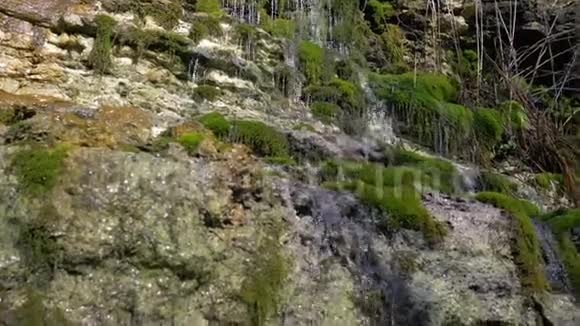 美丽的自然瀑布淡水从长满青苔的石头中流过风景优美视频的预览图