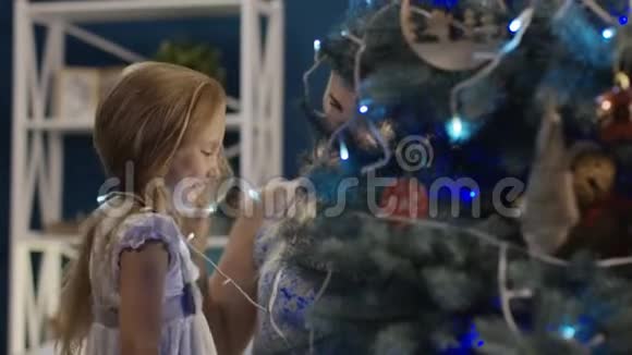 内容女人和小女孩装饰圣诞树视频的预览图