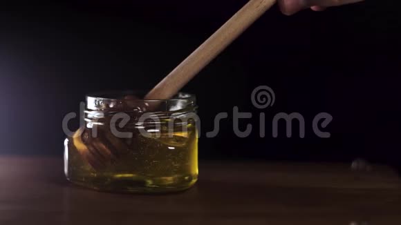 蜂蜜滴从罐子里的蜜汁里倒出来特写镜头厚厚的蜂蜜浸泡视频的预览图