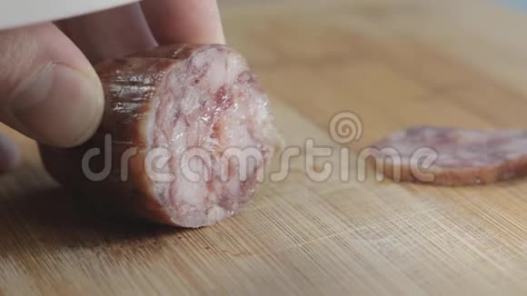 香肠用白色陶瓷刀切在木板上视频的预览图