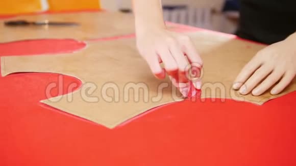 年轻女子用手臂假体在红布上做素描双手集中视频的预览图