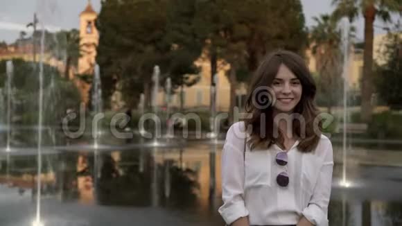 一位美丽的旅游妇女站在法国街上的喷泉旁大笑视频的预览图