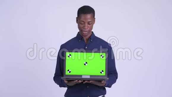 年轻快乐的非洲商人一边说话一边展示笔记本电脑视频的预览图